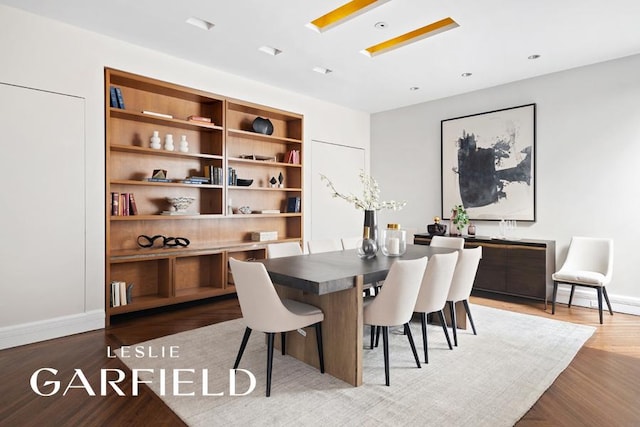 dining space featuring built in shelves and wood-type flooring