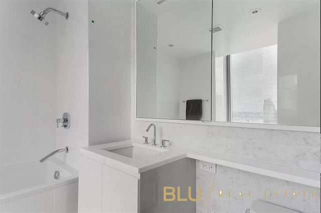 bathroom featuring tiled shower / bath and vanity