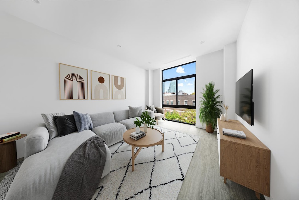 living room with a wall of windows and wood finished floors