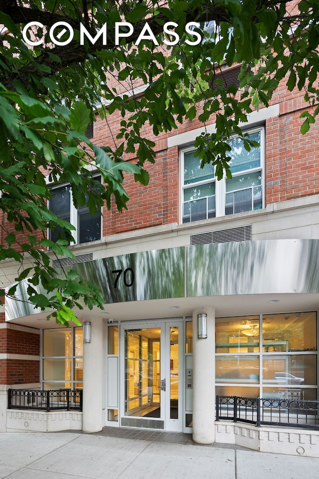 property entrance featuring french doors and brick siding