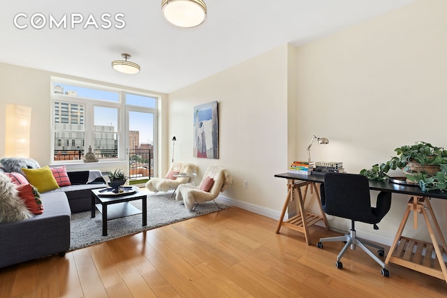 living room featuring baseboards, wood finished floors, and a view of city