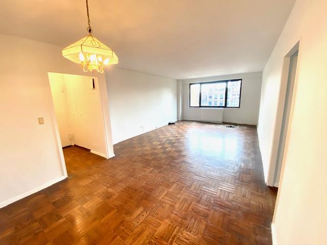 unfurnished room with a notable chandelier and dark parquet floors