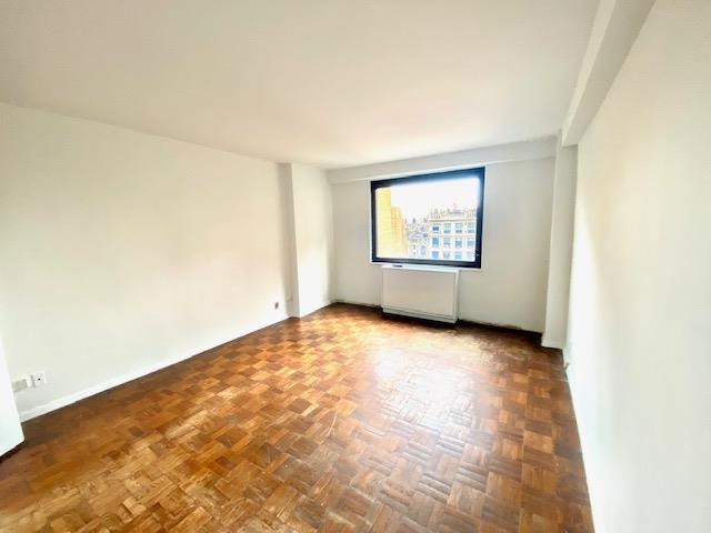 unfurnished room featuring dark parquet flooring and radiator