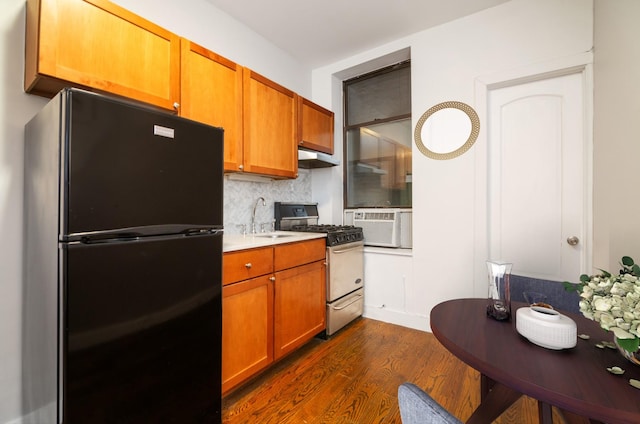 kitchen with dark wood-style flooring, a sink, freestanding refrigerator, tasteful backsplash, and gas range