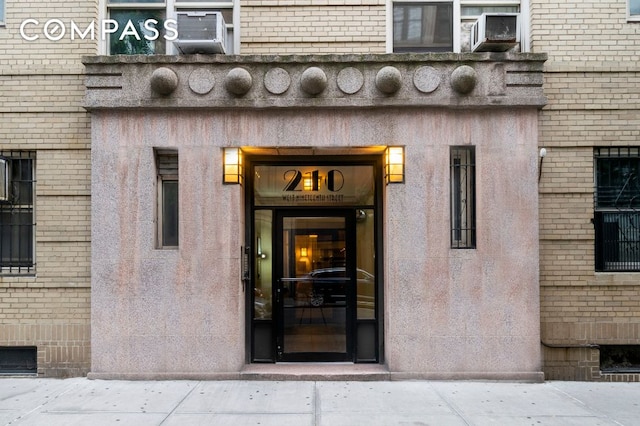 view of exterior entry featuring brick siding