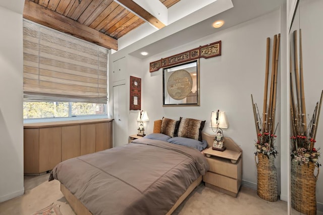 bedroom featuring wood ceiling, light colored carpet, and beamed ceiling