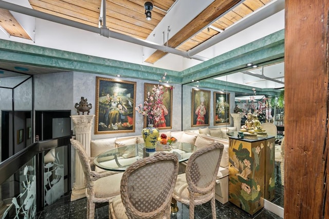 dining space featuring granite finish floor and beam ceiling