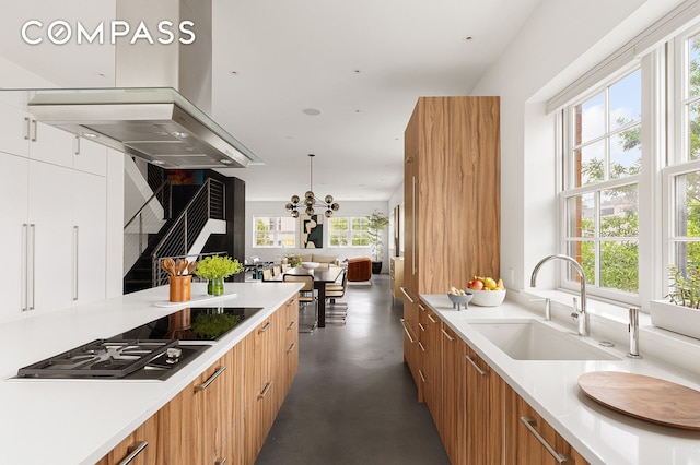 kitchen with stovetop, modern cabinets, concrete floors, and a sink