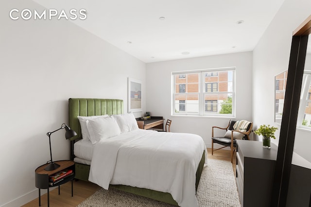 bedroom with light wood-style flooring and baseboards