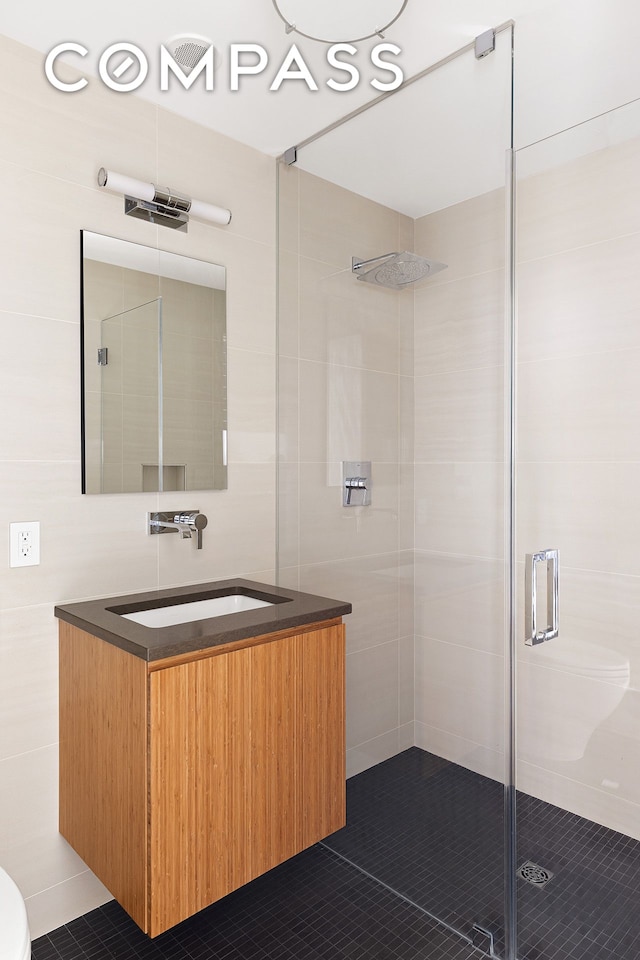 full bathroom with vanity, toilet, tile walls, and a shower stall