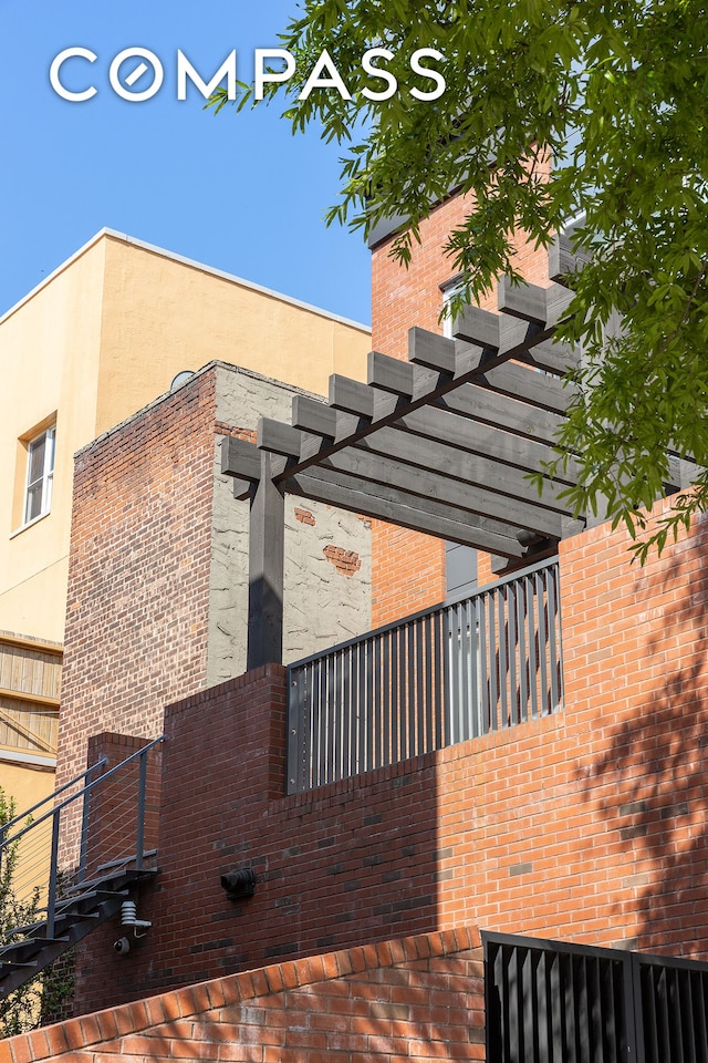 view of side of home featuring stucco siding and a pergola