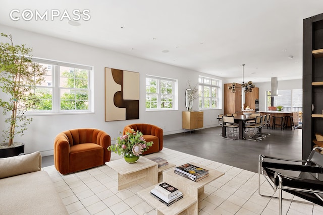 living area with baseboards and a chandelier