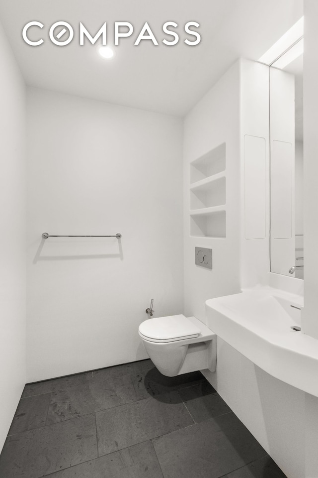 bathroom featuring toilet and built in shelves