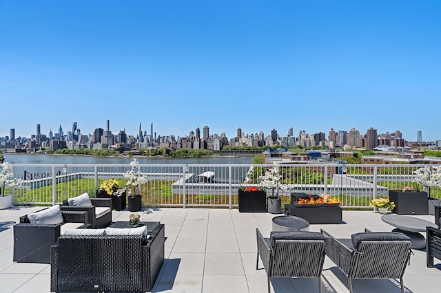 view of patio / terrace featuring a city view, fence, a water view, and an outdoor hangout area