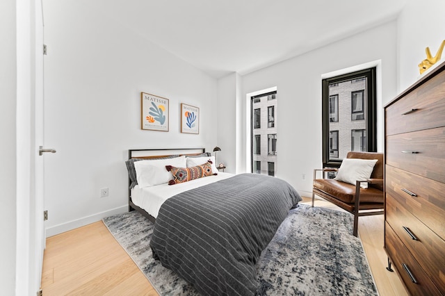 bedroom featuring light wood-type flooring and baseboards