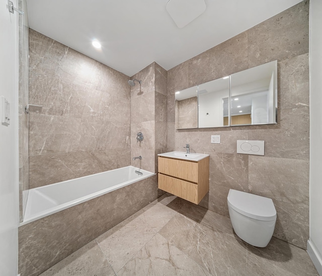 bathroom featuring vanity, toilet, tile walls, and tiled shower / bath combo