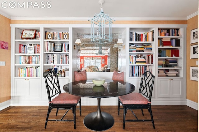 dining area featuring crown molding, dark hardwood / wood-style floors, and an inviting chandelier