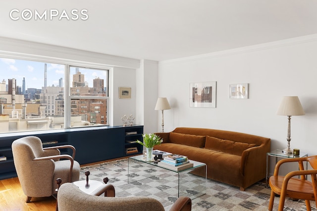 living room with wood finished floors, a city view, and ornamental molding