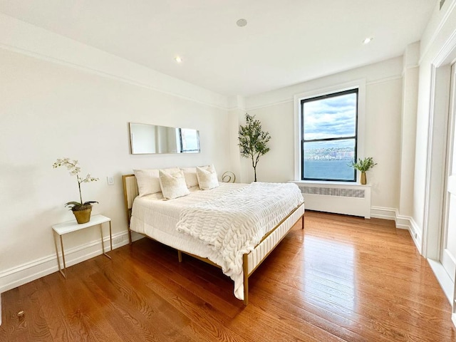 bedroom featuring radiator and light hardwood / wood-style floors