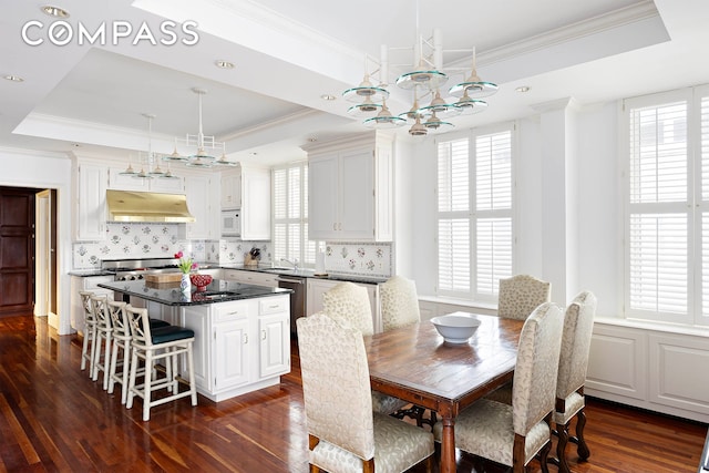 dining space featuring a chandelier, crown molding, a raised ceiling, and dark wood-type flooring