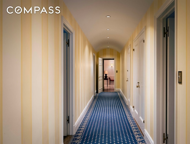 hall with recessed lighting, baseboards, and vaulted ceiling