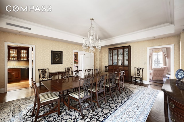 dining space with visible vents, wallpapered walls, an inviting chandelier, ornamental molding, and a raised ceiling