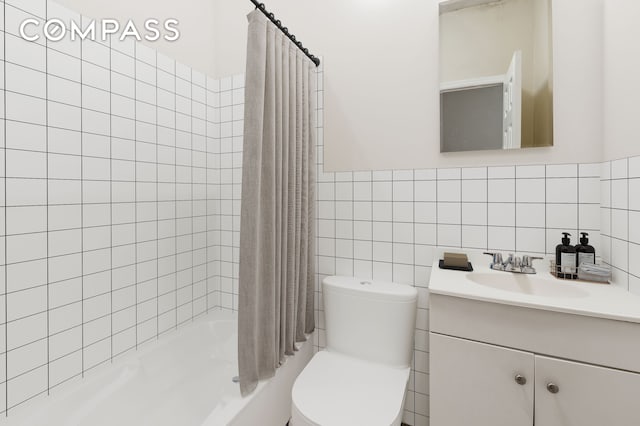 full bath featuring toilet, tile walls, wainscoting, shower / tub combo, and vanity