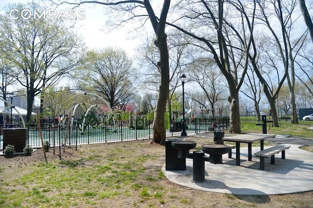 view of property's community with playground community and fence