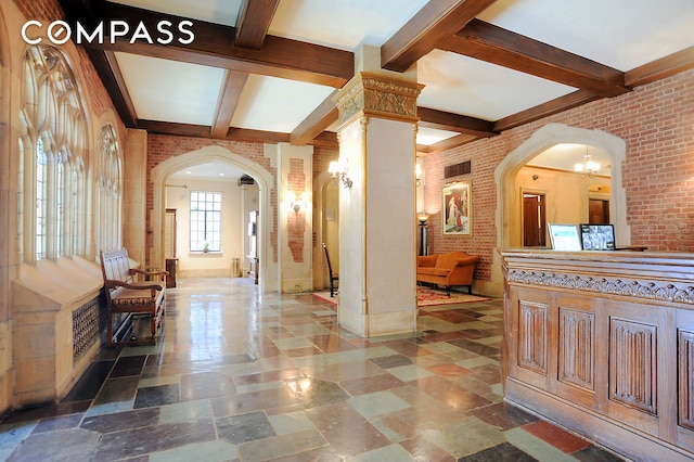 interior space featuring beamed ceiling, decorative columns, arched walkways, and brick wall