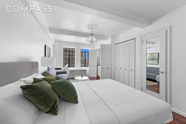 bedroom featuring beamed ceiling, dark wood-style floors, a closet, baseboards, and a chandelier