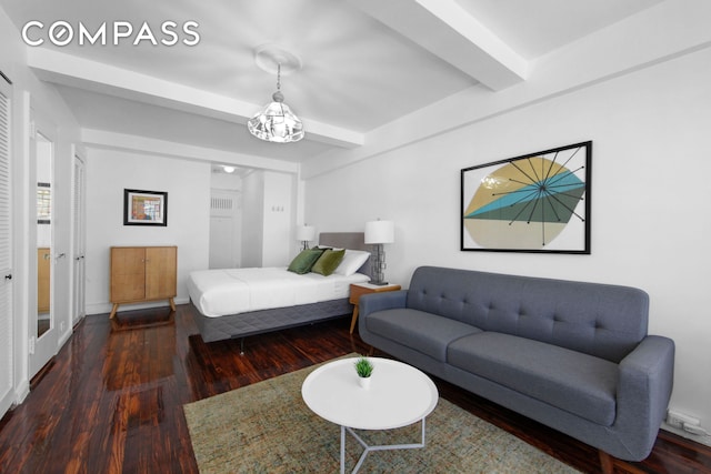 bedroom featuring a chandelier, beam ceiling, and wood finished floors