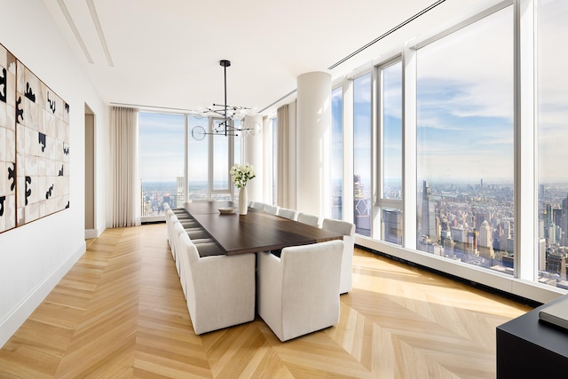 dining room with baseboards, a view of city, a chandelier, and floor to ceiling windows