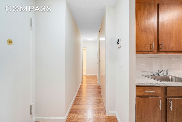 hall with sink and light hardwood / wood-style flooring