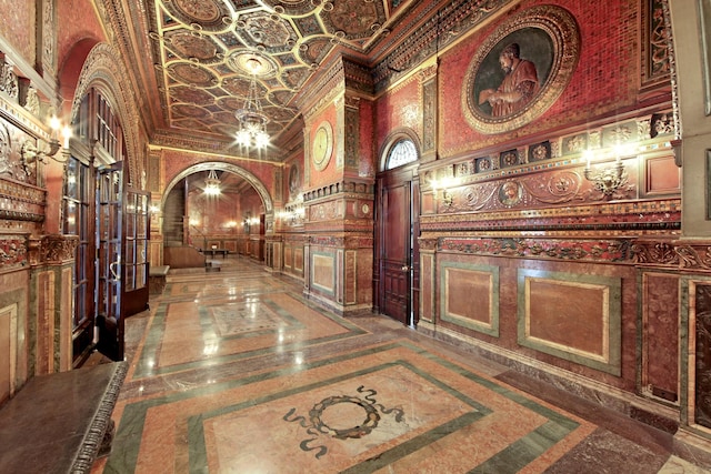 205 W 57th St Unit 4-Aa, New York City, NY 10019 - hallway featuring inlaid floor details, a high ceiling, marble tiled floors, arched walkways, and a chandelier
