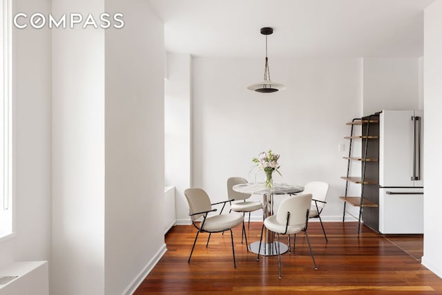 dining space with dark hardwood / wood-style flooring