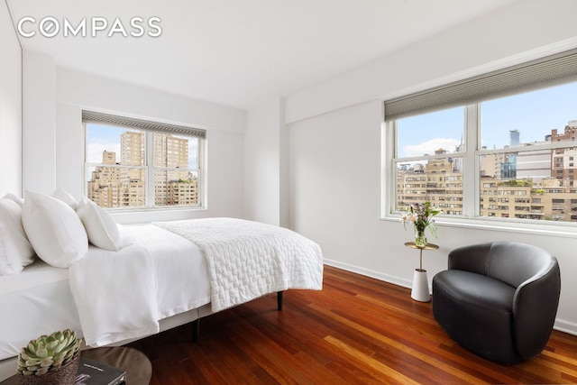 bedroom with hardwood / wood-style flooring and multiple windows