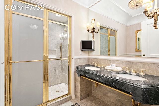 full bath featuring a sink, tile walls, a shower stall, and crown molding