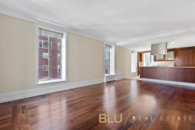 unfurnished living room featuring dark hardwood / wood-style floors and crown molding