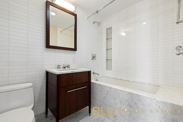 bathroom with toilet, tile walls, vanity, and bathtub / shower combination