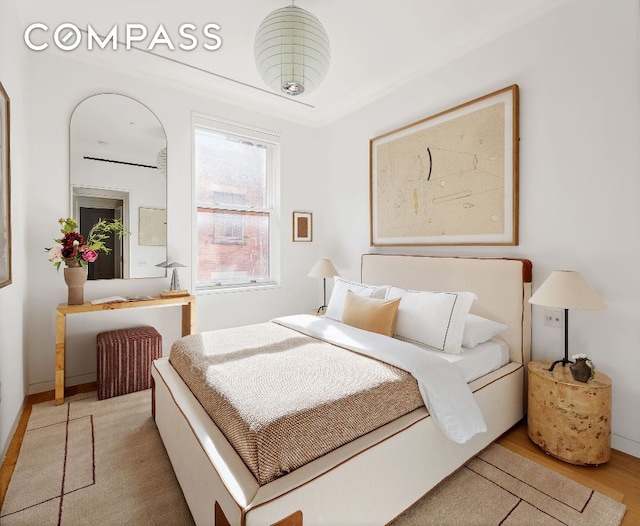 bedroom with light wood-style flooring and baseboards