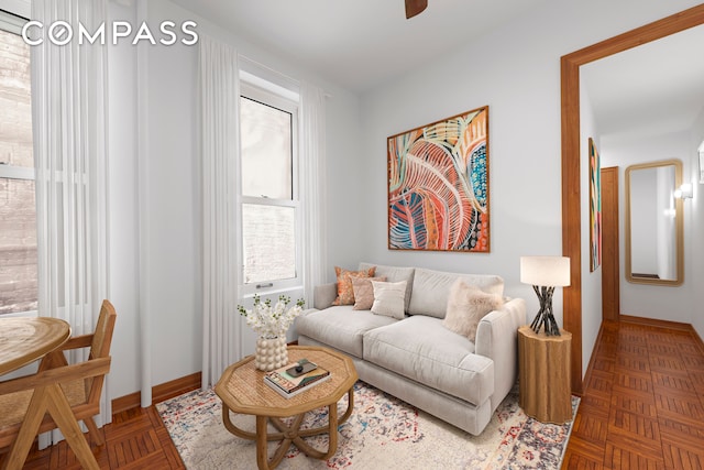 living room with ceiling fan and baseboards