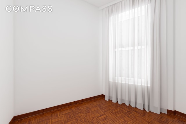 unfurnished room with baseboards