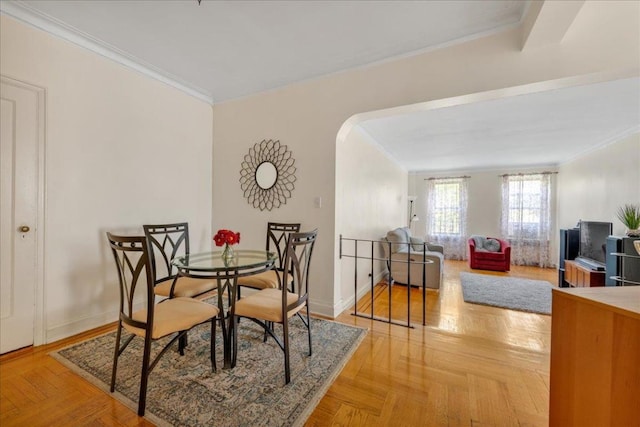 dining area featuring crown molding and light parquet floors