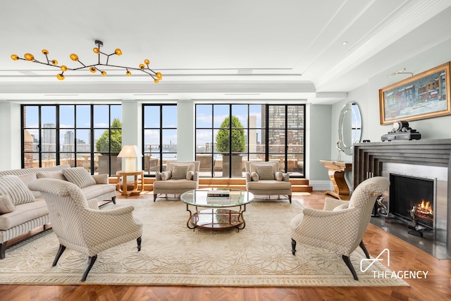 living room featuring a fireplace with flush hearth, expansive windows, and a tray ceiling