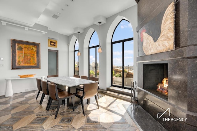 dining space featuring parquet floors and a large fireplace