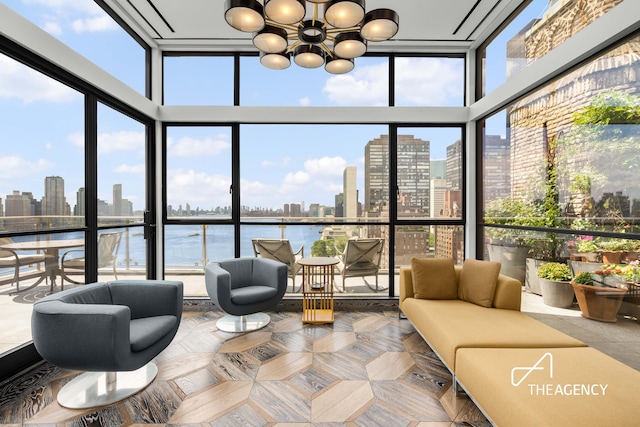 sunroom with a healthy amount of sunlight, a chandelier, and a city view