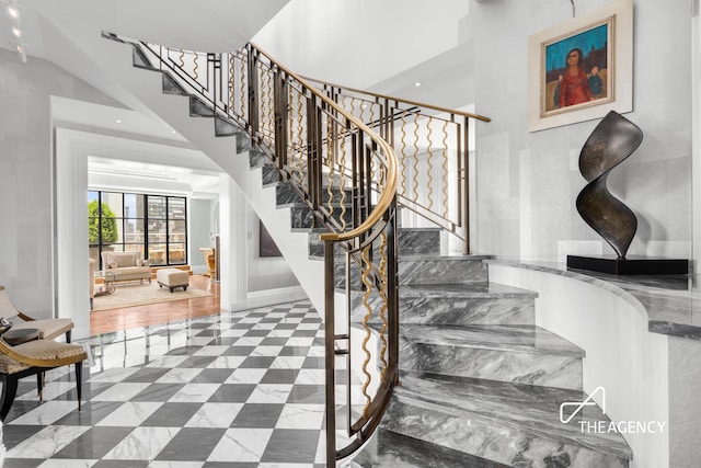 stairs with a high ceiling, recessed lighting, and baseboards