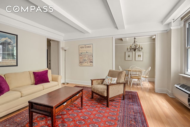 living area with light wood finished floors, baseboards, beamed ceiling, a wall mounted air conditioner, and an inviting chandelier