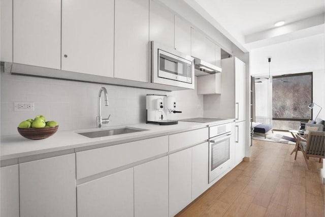 kitchen featuring appliances with stainless steel finishes, sink, decorative backsplash, and white cabinets