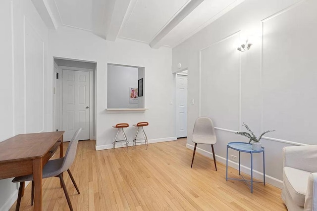 living area with beam ceiling and hardwood / wood-style flooring